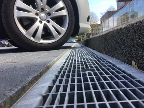 Canale di drenaggio nel parcheggio contro un marciapiede