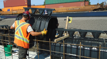 łatwy montaż recyfix hicap na budowie, pracownik trzyma koryto w rękach